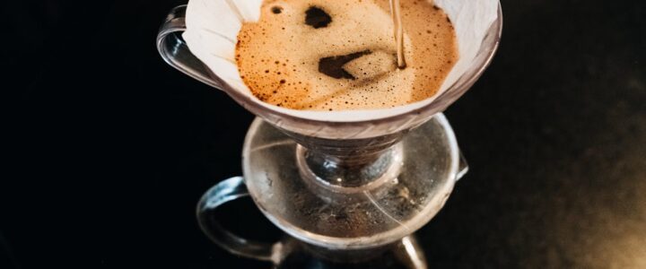 Person pouring water over a pour-over coffee filter for eco-friendly brewing